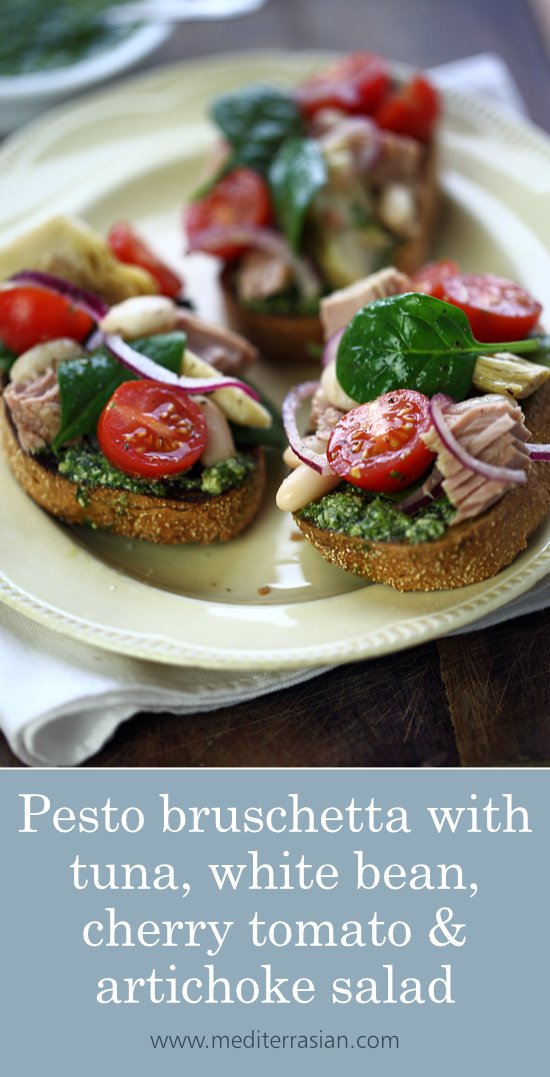 Pesto bruschetta topped with tuna, white beans, cherry tomatoes and artichokes